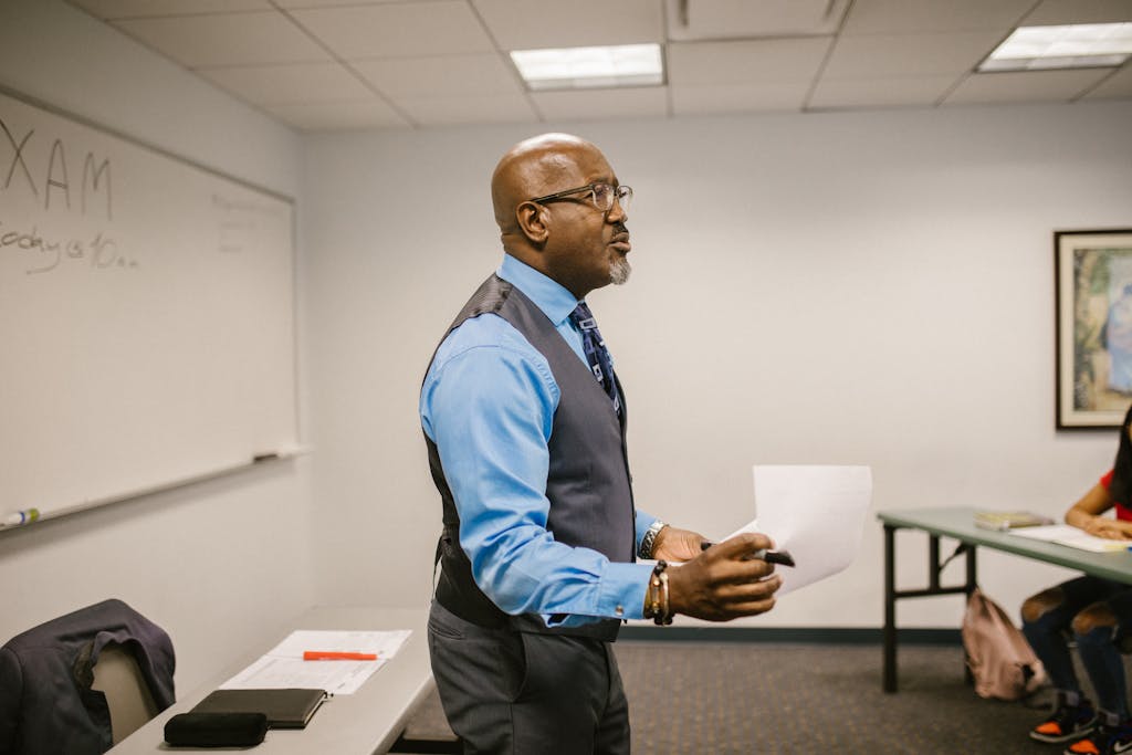 A teacher reviewing exam details with students in a classroom setting.